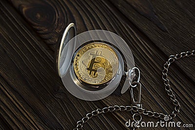 The physical bitcoin and vintage pocket watch shows that time is running out. Stock Photo