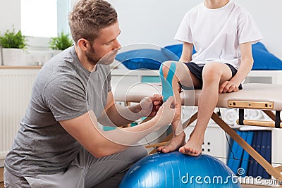 Physical therapist applying medical tape Stock Photo