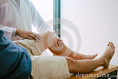 Physical therapists are using the handle to the patient knee to check for pain Stock Photo