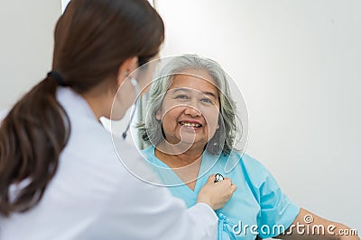 Physician examining heart with a stethoscope and talking with a senior woman at a clinic for check yearly checkup, Medicine health Stock Photo