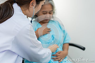 Physician examining heart with a stethoscope and talking with a senior woman at a clinic for check yearly checkup, Medicine health Stock Photo