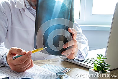 Physician indicates to patient during appointment at elbow radiograph, indicating possible cause and location of disease, such as Stock Photo