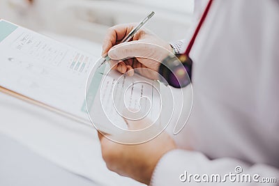 Physician noting down symptoms of a patient Stock Photo