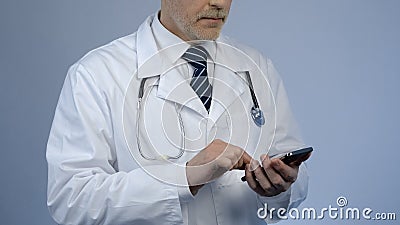 Physician typing message on cellphone, online consultation, modern technologies Stock Photo