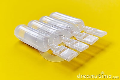 Physiological serum ampoules on a yellow background Stock Photo