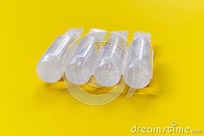 Physiological serum ampoules on a yellow background Stock Photo