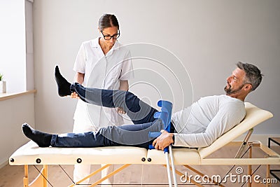 Physiotherapist Checking Man Patient Knee Stock Photo