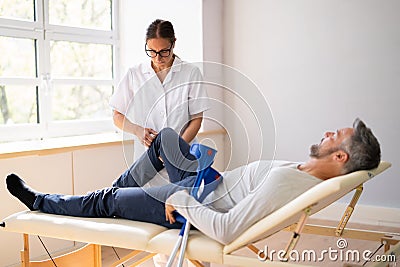 Physiotherapist Checking Man Patient Knee Stock Photo