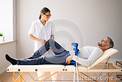 Physiotherapist Checking Man Patient Knee Stock Photo