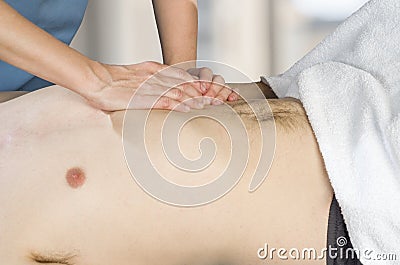 Physiotherapist, chiropractor is doing an activation of the diaphragm. Massage to a man patient. Osteopathy Stock Photo