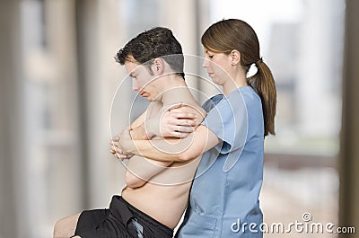Physiotherapist, chiropractor is doing a global dorsal manipulation for a male patient Stock Photo
