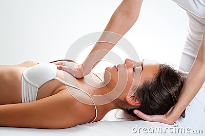 Physiotherapist doing thorax manipulation on woman. Stock Photo