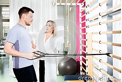 Physiotherapist helps a patient to restore movement Stock Photo