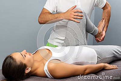 Physiotherapist manipulating female leg at therapy session. Stock Photo