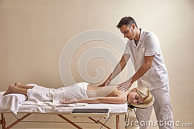 Physiotherapist massage, woman back laying on bed. full lenght shot. Stock Photo