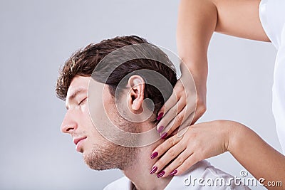 Physiotherapist palpationing patient with stiff neck Stock Photo