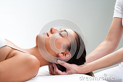 Physiotherapist pressing back of woman's head. Stock Photo