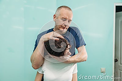Physiotherapist is rehabilitating young woman neck in medical office Stock Photo