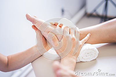 Physiotherapist working with woman giving her massage. Modern rehabilitation physiotherapy. Therapist treating injured legs of ath Stock Photo