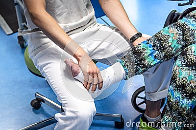 Physiotherapists doing a simple medical act on elderly person Stock Photo