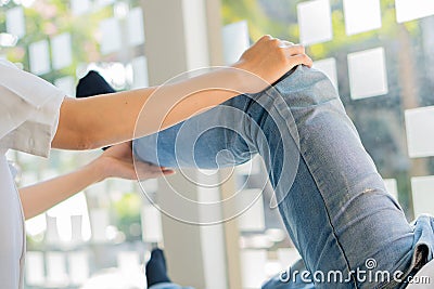 Physiotherapy concept image of a young man with injured leg giving doctor massage patient leg giving medical treatment for spraine Stock Photo