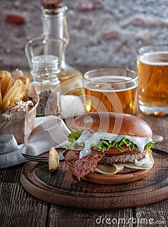 Piano burger with bacon and cutlet with cheese, tomato, greens. Stock Photo