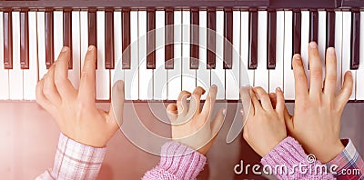 Piano Keyboard top View and Hands of Child Mother and Father Stock Photo