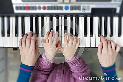 Piano Keyboard top View and Hands of Child and Mother Stock Photo