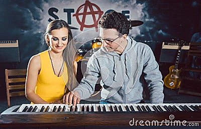 Piano teacher giving music lessons to his student Stock Photo