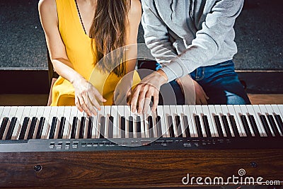 Piano teacher giving music lessons to his student Stock Photo