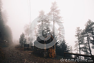 House in the foggy forest in a winter mountain Stock Photo