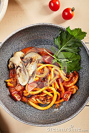 Pichi with mushrooms and creamy tomato allione in gray bowl top view Stock Photo