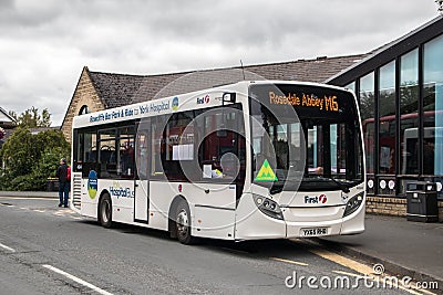White First Bus, public transport parked at a bus stop on a street road Editorial Stock Photo