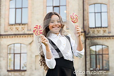 Picking flavour is hardest part. Schoolgirl choosing sweets. Happy kid with sweet candy. Kid child holding lollipops Stock Photo