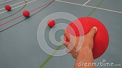 Picking up a dodgeball in my left hand Stock Photo