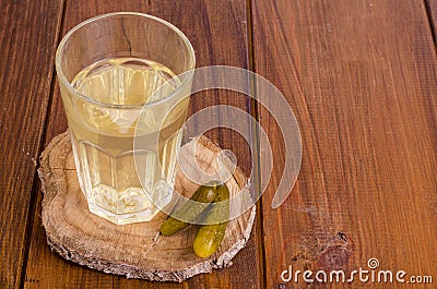 Pickle juice glass, pickled cucumber on wood Stock Photo