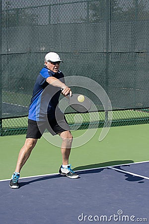 Pickleball Action - Senior Man Returning A Serve With A Backhand Stroke Stock Photo