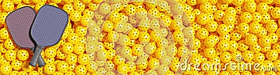 Pickleball. Two rackets lie on a large pile of yellow sports balls. Stock Photo