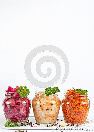 Pickled and fermented homemade vegetables. Sauerkraut, marinated red cabbage and carrot in glass jars with copy space Stock Photo