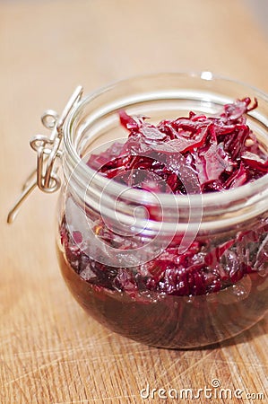 Fermented red cabbage in a glass jar on a wooden table. Healthy vegetarian food with vitamins Stock Photo