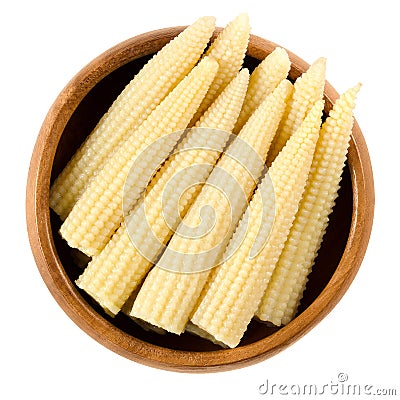 Pickled whole baby corn in wooden bowl over white Stock Photo