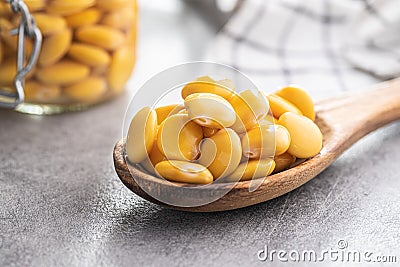 Pickled yellow Lupin Beans in wooden spoon Stock Photo