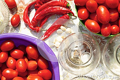 `Pickling vegetables process` canning the tomatoes and chili pepper. Glass jars with tomatoes. Stock Photo