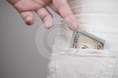 Pickpocket stealing. Man stel one hundred US dollar money from back woman pocket/ Stock Photo