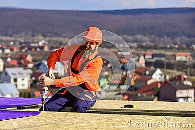 Picky inspector. new roof under construction residential building. builder use drill. professional master repair roof Stock Photo
