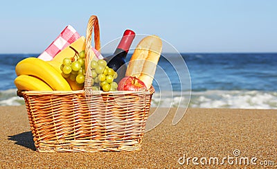 Picnic basket with food on beach Stock Photo