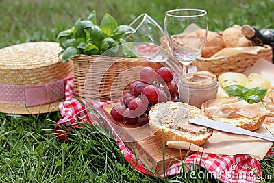 Picnic blanket with wineglasses and food on green grass Stock Photo