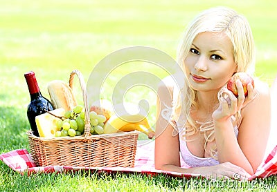 Picnic. Blonde young woman with basket of food Stock Photo