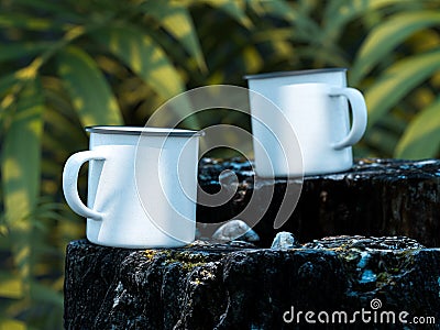 Picnic And Camping Rest Of Travelers: White Blank Enameled Mugs With Copy Space On Rock In Exotic Forest. 3d rendering. Stock Photo