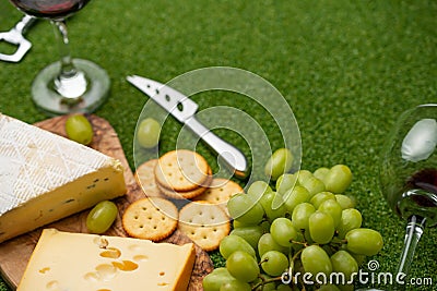 Picnic Green Grass Cheese Red Wine Grapes The concept of a picnic, summer and rest Stock Photo